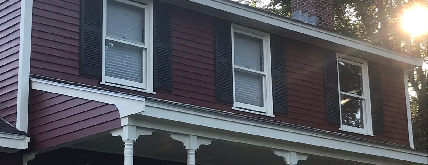 A repainted New England home and porch in late afternoon light