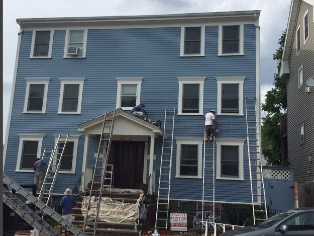 The same three-family home after a full Stanley Painting exterior repaint