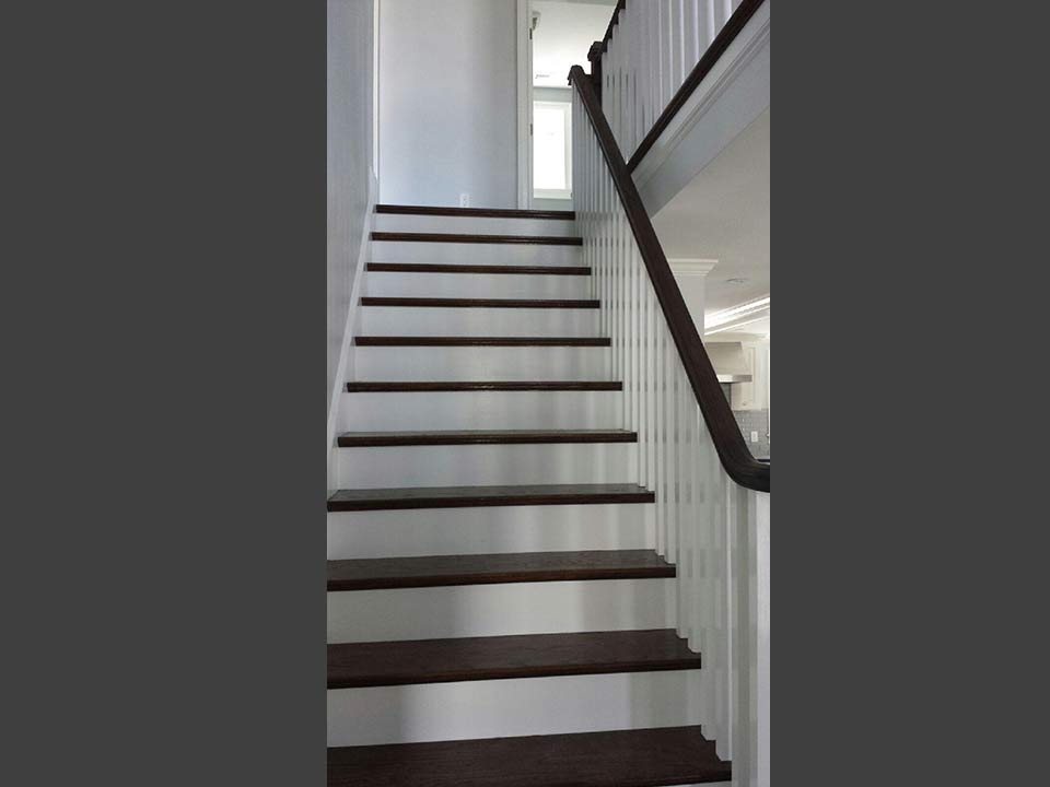 Stairwell with hand-cut white trim and stained treads